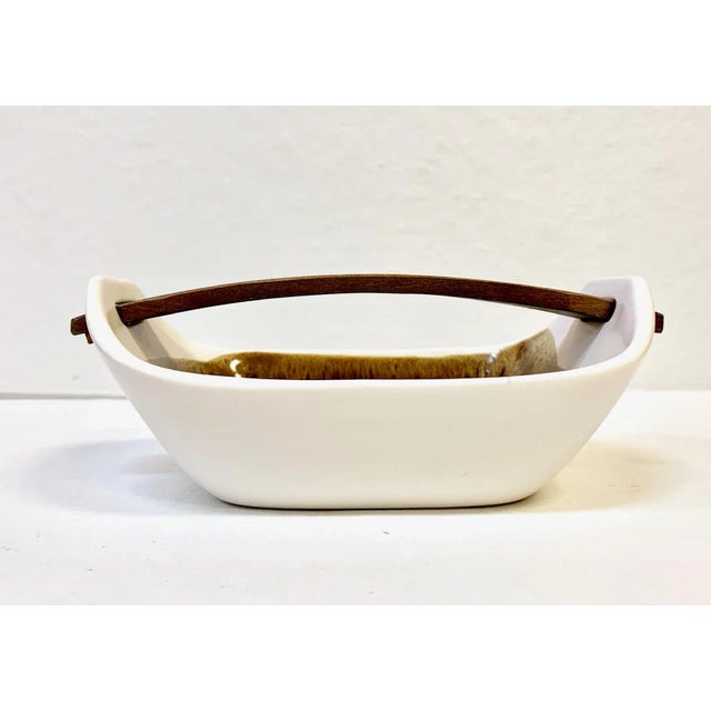 Handmade from Scandinavia, low bowl style dish with an integrated bowed wood handle. Brown glaze interior of bowl. Circa...