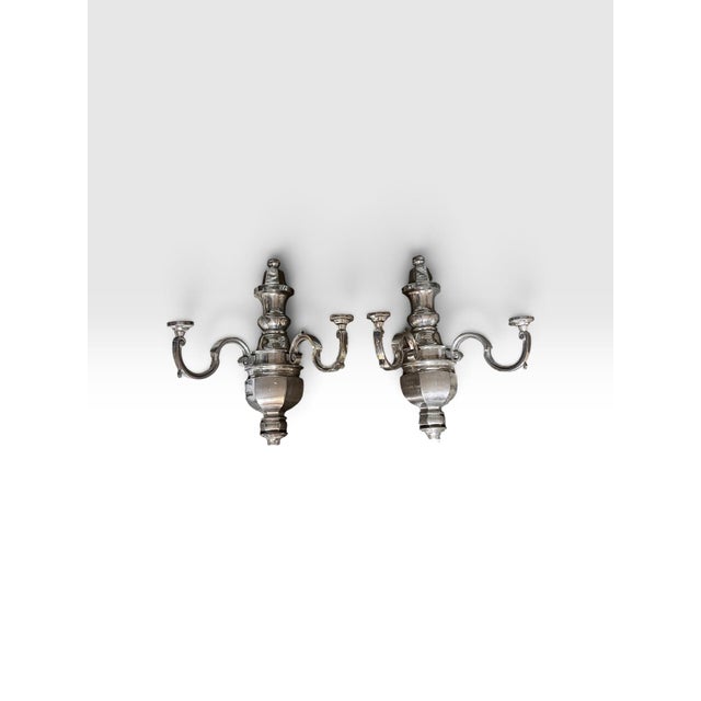 Dramatic pair of oversized polished aluminum wall sconces featuring an elegant Neoclassical urn-form body and gracefully...
