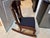 Antique child-size wooden rocking chair with a low profile, upholstered seat, and distinctive vase-form central back splat...