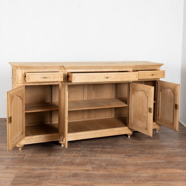 20th century long sideboard buffet from Belgium, crafted in bleached oak. The case features three drawers over four...