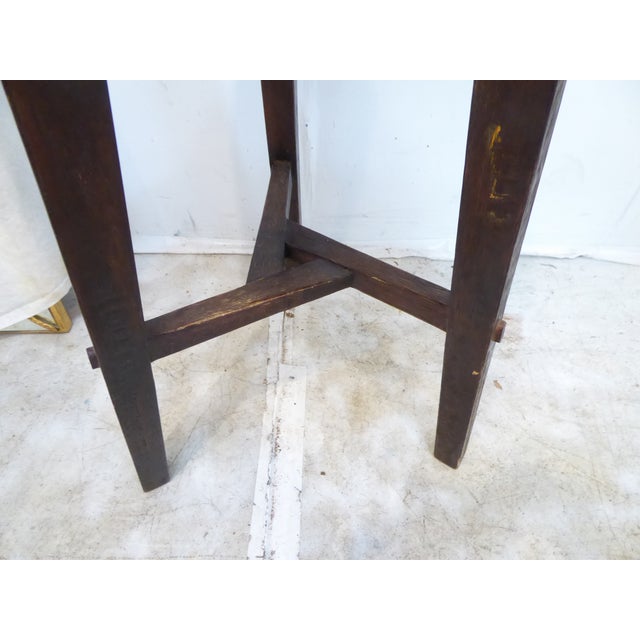 This rustic end table has a crossbar and dished top.