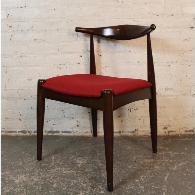 Set of six mid-century modern styled dining chairs with sculptural frames. Distinctive horn or wishbone backs that support...