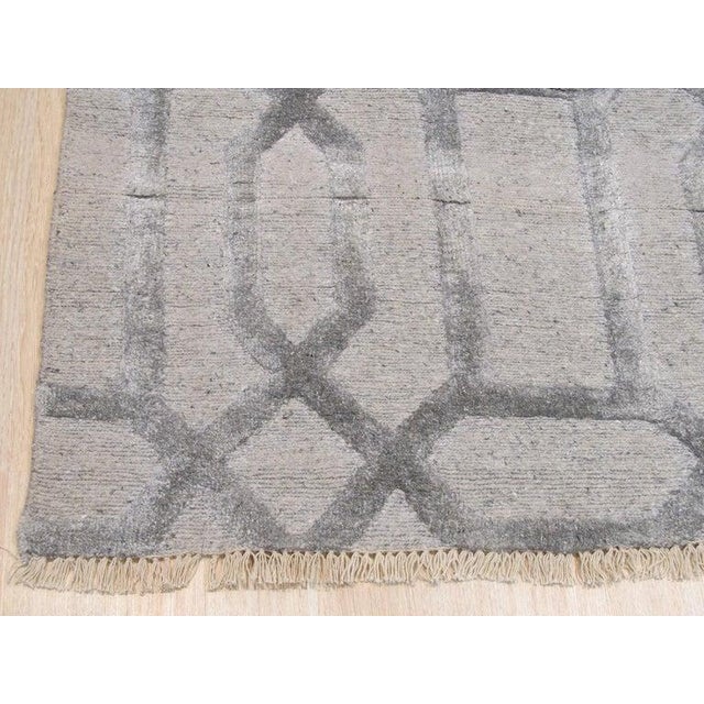 This gray hand knotted pile rug is a contemporary floor covering crafted from a blend of wool and viscose. Produced in...
