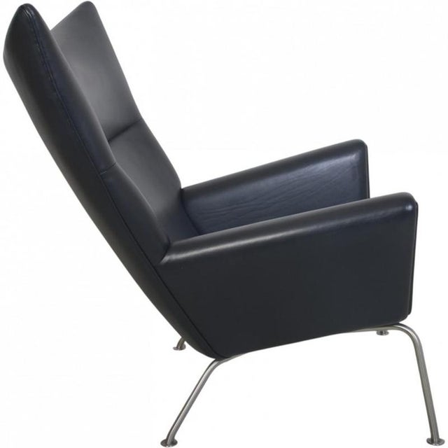 Hans Wegner CH445 Wing chair upholstered in black leather. The chair is from the 1990s but was later upholstered in the...