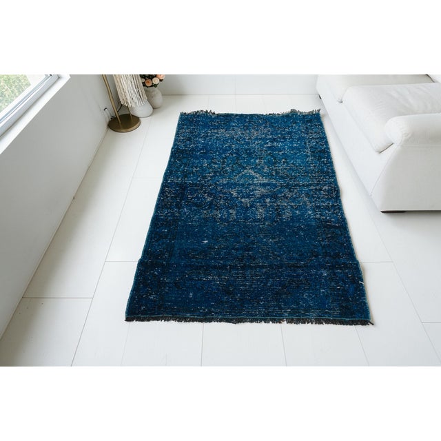 This is a vintage Turkish Oushak rug from the Mid 20th Century. The piece was hand-knotted.