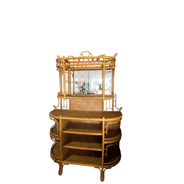 A vintage bent rattan dry bar or hutch perfect for a coastal or bohemian setting. The upper section has a mirror and a...