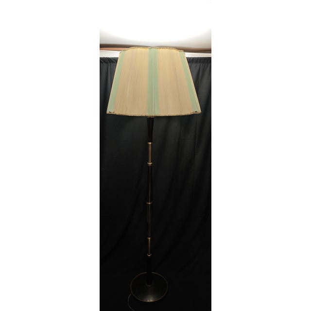 Vintage wooden floor lamp with brass details, dating back to the late 1950s or early 1960s. The frame features a refined...