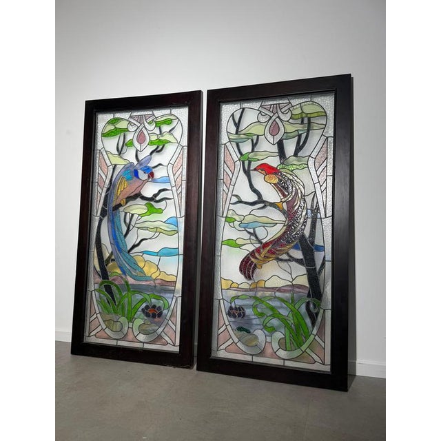 Decorative pair of antique stained glass panels featuring beautifully detailed exotic birds surrounded by stylised trees,...