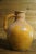 A beautiful yellow glazed pottery jug with a thick braided handle. In good vintage condition. Measures 13.5 inches tall x...