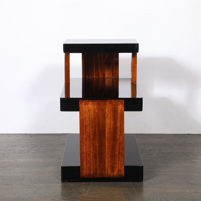 This striking Art Deco Machine Age Three-Tier Black Lacquer & Walnut Side Table originated in the United States, circa...