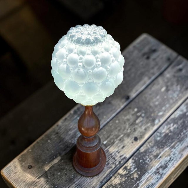 This fabulous table lamp was designed and manufactured in Portugal in the 1970s. It is carved from wood and crowned with a...