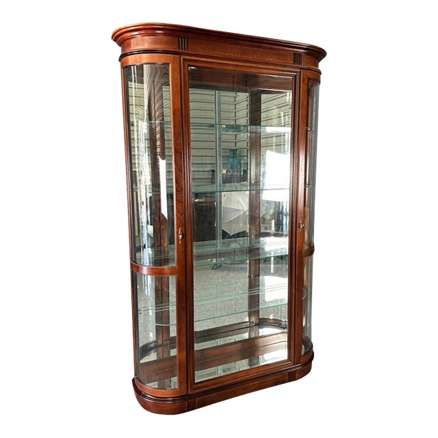 This Pulaski cherry bow front curio cabinet features gracefully curved glass sides and doors that create a panoramic...