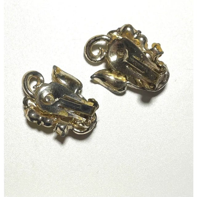 This is part of Chairish’s Costume Jewelry assortment. Sweet 1950s yellow enamel flower earrings with orange crystal...