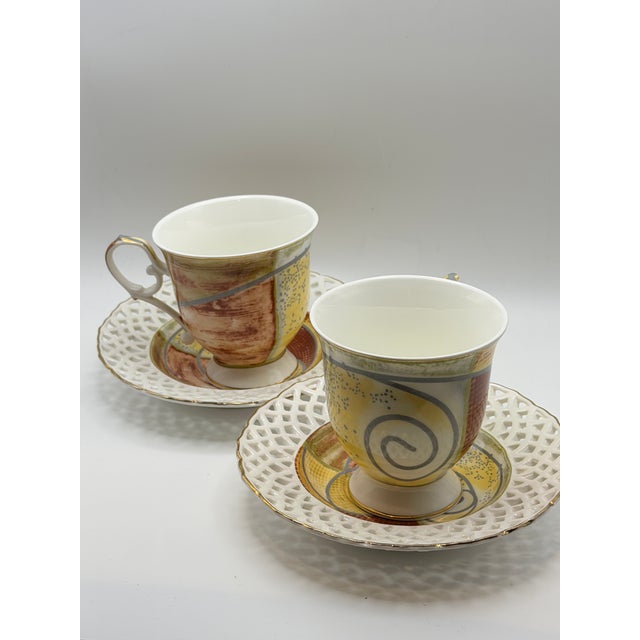 Elegant set of two porcelain cups with matching pierced saucers from the Queen Isabell – Limited Collection. This refined...