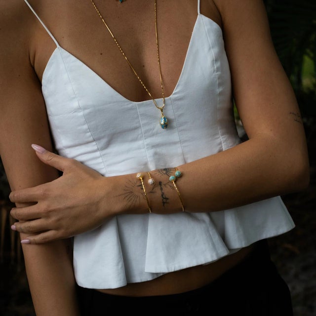 Infuse your style with vibrant energy through the Turquoise Grace Adjustable Gold Cuff Bracelet. Handcrafted from bronze...