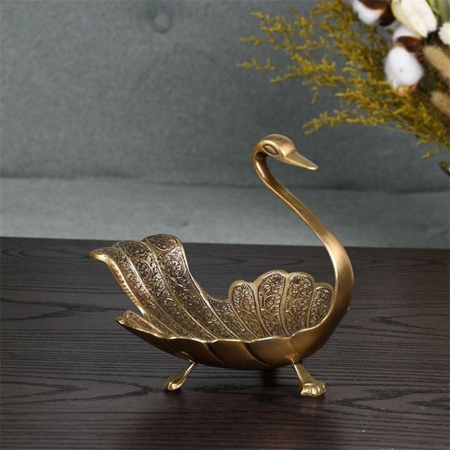 This vintage-style storage tray features an aged gold finish and an elegant swan shape—the swan's wings form the body, the...