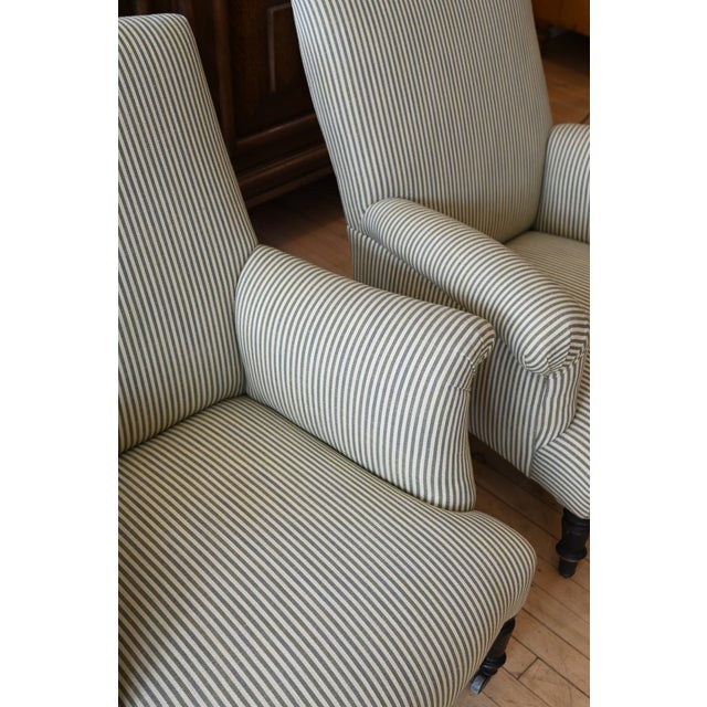 Sophisticated pair of French lounge chairs circa 1930. Stylish with high backs, rolled arms and turned legs finished with...