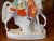 A large and colorful Staffordshire equestrian figure, the rider in a feathered hat and green cape mounted on a dappled...