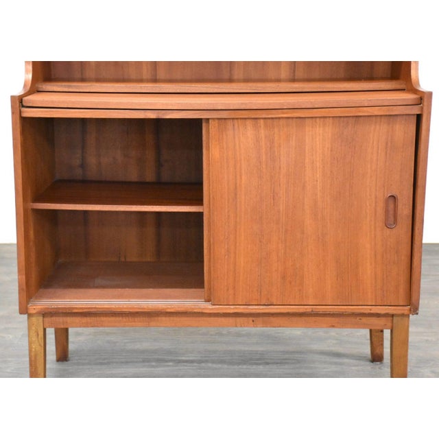 A mid century modern teak secretary desk with a pull out writing surface and upper bookshelf. Made in Denmark. Circa...