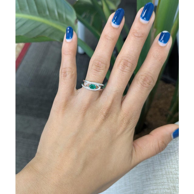 Elegant Zambian emerald ring featuring a natural oval 6×4 mm gemstone, accented with sparkling diamonds in solid 14K gold....