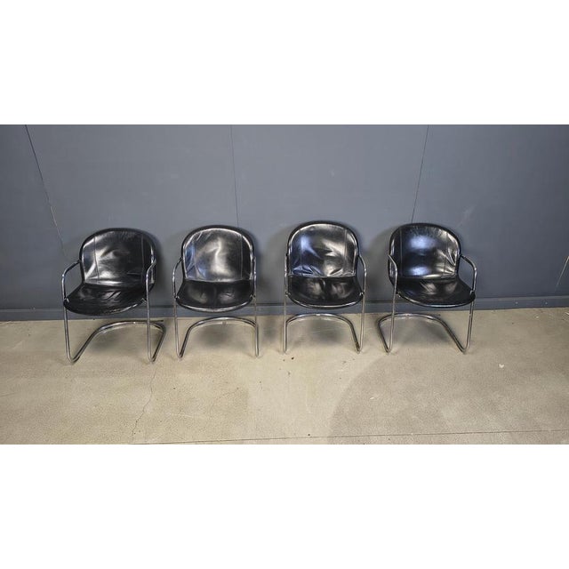 Vintage dining room chairs with a chromed cantilever design frame and thick and comfy black leather seats. Beautiful...