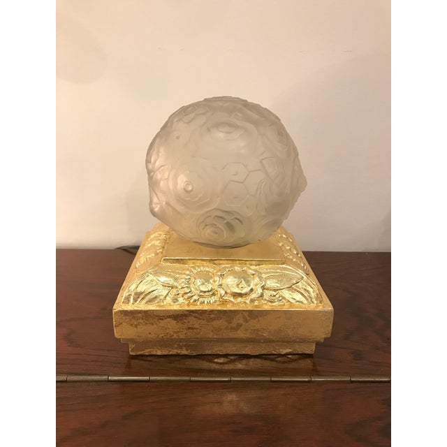 Pair of French Art Deco table lamps by Marius Ernest Sabino, (1878-1961). The floral shades are clear frosted glass with...