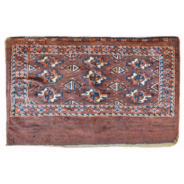 A late 19th century Persian Yamout rug composed with multiple stylized floral medallions woven in crimson, white, indigo,...