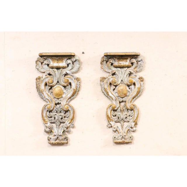 An Italian pair of beautifully carved and painted wood corbels from the 18th century. These antique decorative wall...
