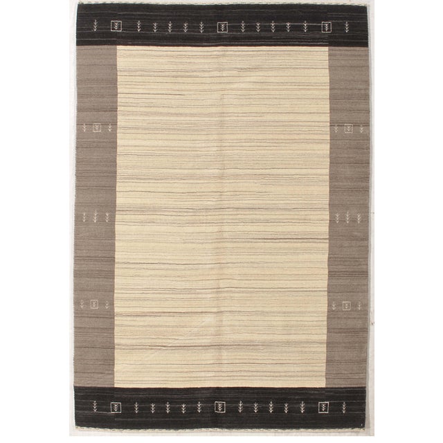 Vintage Hand-knotted Gabbeh rug featuring a soft ivory field with fine horizontal striations, framed by contrasting taupe...