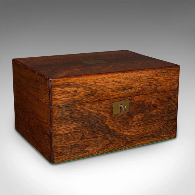 This is an antique vanity case. An English, rosewood and brass travelling dressing table box, dating to the Regency...