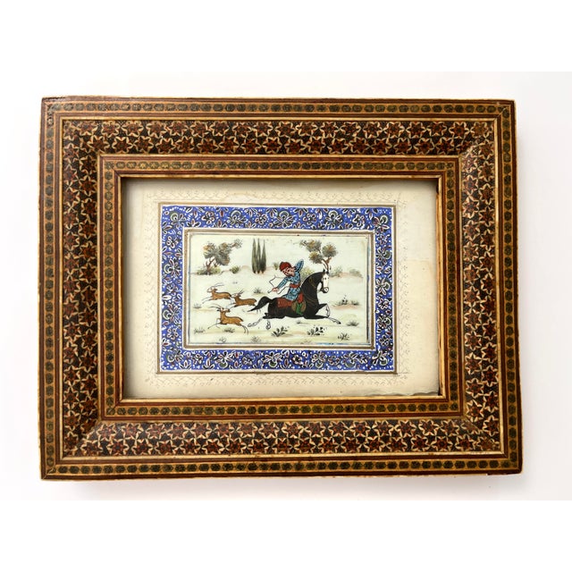 This intricate Persian miniature depicts a classic hunting scene, a central theme in Safavid-era art, featuring a nobleman...