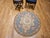 This vintage round needlepoint rug features an elegant floral design in red, green, brown, and ivory set against a crisp...
