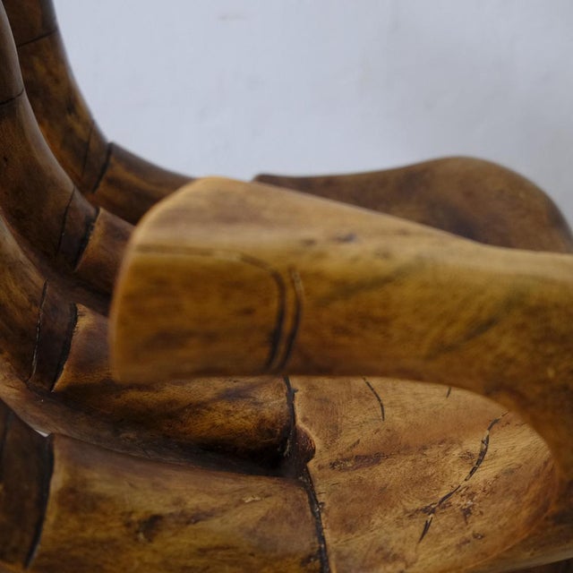 Chair, table in carved wood in the shape of a hand.