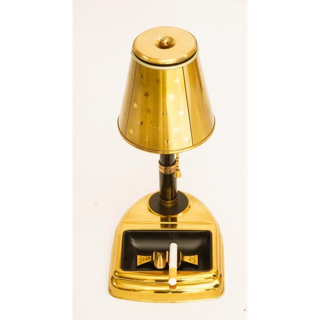 Details: -Cigarette holder made of light gold-tone metal -Cigarette holder in the shape of a lamp with base that serves as...