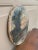 A beautiful antique hand-painted oil on canvas landscape painting featuring a waterfront scene with trees and a boat in...