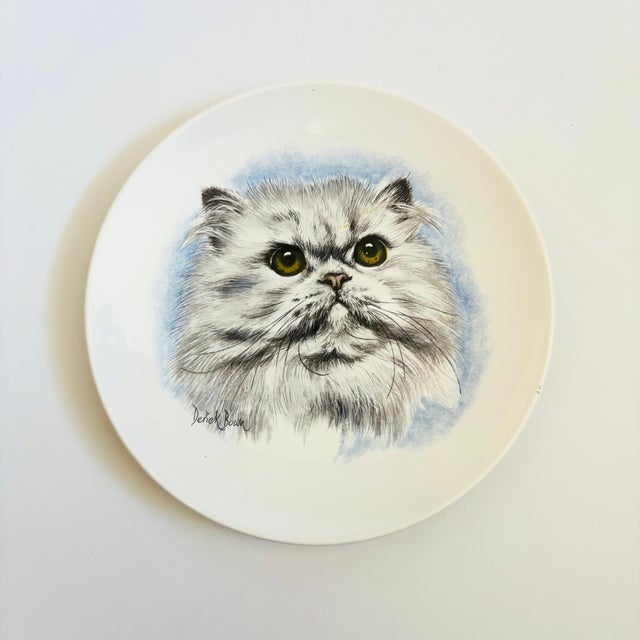 A circular vintage ceramic plate with the design of a cat. Made by Poole, England and marked on the back. Measures 6"Dia x...
