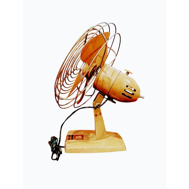 This is a vintage Toastmaster oscillating fan featuring distinctive yellow blades, an open wire safety cage, and a heavy...