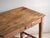 This antique kitchen table in pine wood carries a frieze drawer with a porcelain knob and stands on four squared legs tied...