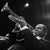 This black-and-white photo captures jazz legend Louis Armstrong playing his trumpet during a performance in Berlin in...