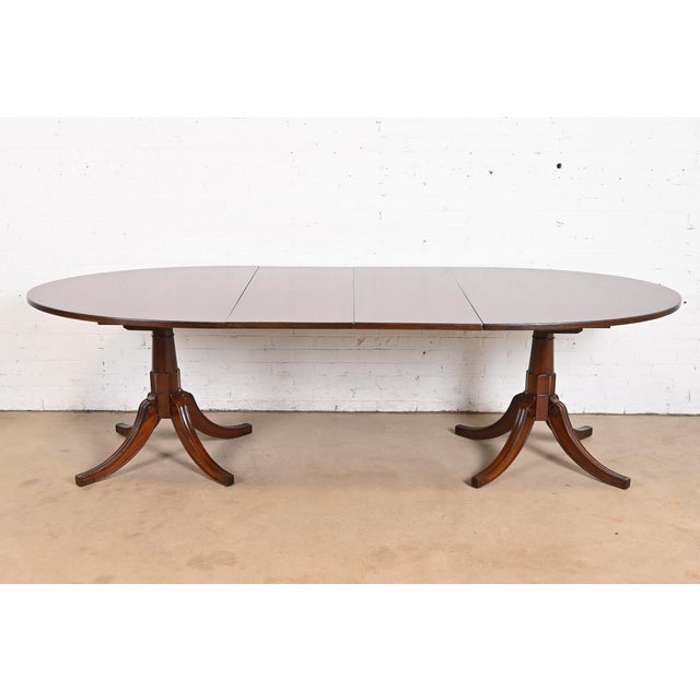 A gorgeous Georgian or Regency style double pedestal extension dining table In the manner of Baker Furniture USA, Mid-20th...
