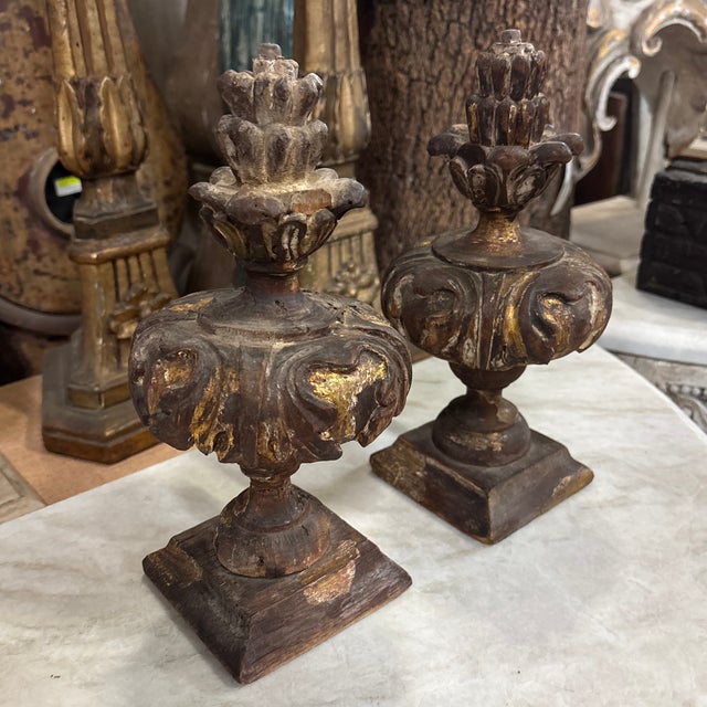 A pair of Italian gilt wood urns from the 18th century. This pair of wood carved urns show a deep patina from their very...