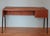 A very elegant desk from the 1960s. The desk's frame is made of teak, and the tapered, slightly angled legs are painted...