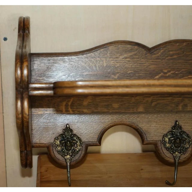 A lovely, heavily carved Dutch oak wall hanging coat hat and scarf rack with French Royalty head gold gilt brass hooks. A...