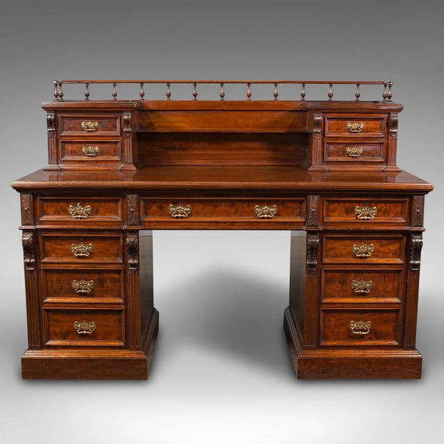 This is a grand antique executive desk. An English, satinwood and mahogany 13 drawer office desk, dating to the mid...