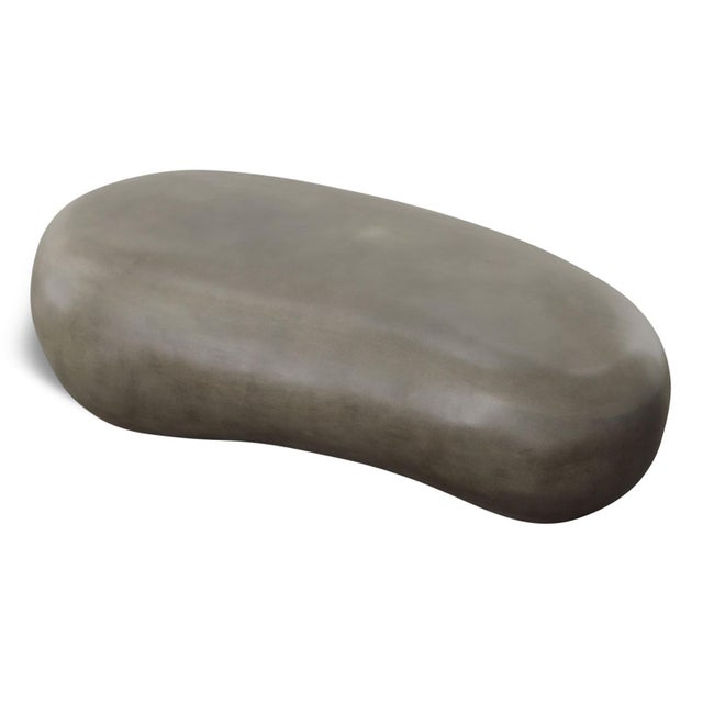 Organic modern sculptural pebble-inspired coffee table, crafted from lightweight concrete in a rich dark grey finish....