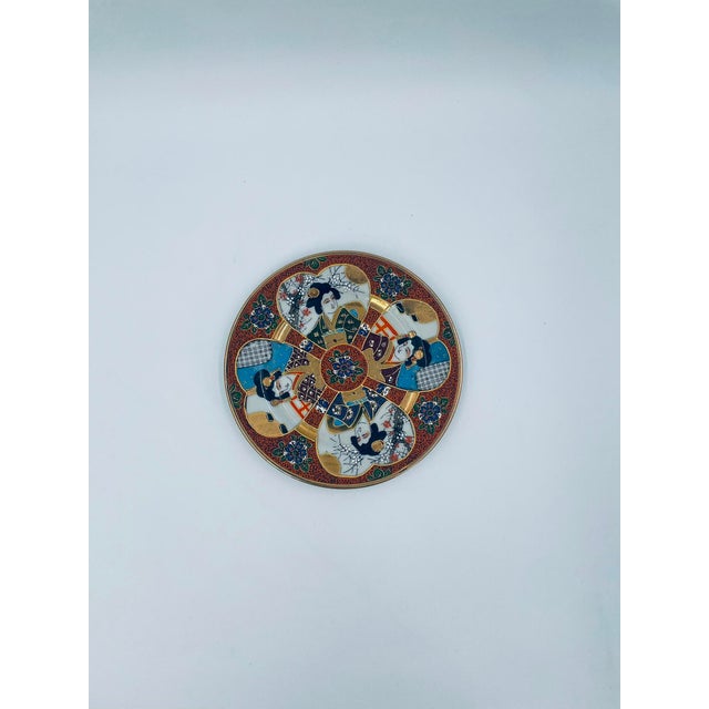 A dessert plate produced in Japan between the 1930s and 1950s in the opulent Satsuma, Kutania style, made of high-quality,...