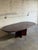 This dining table features a stunning oval top and a striking cross-pedestal base. The elegant design incorporates...