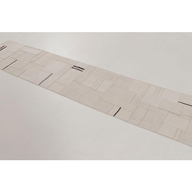 This 2x10 vintage Turkish kilim runner is a mid-century flatweave, handwoven in hemp and composed in a patchwork...