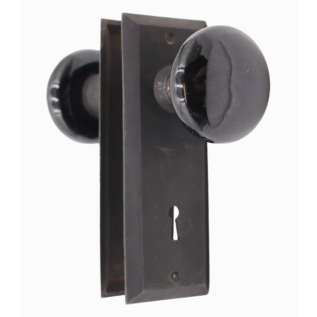 Vintage Classic style passage door knob set made with black ceramic round knobs and rectangular cast iron back plates. The...