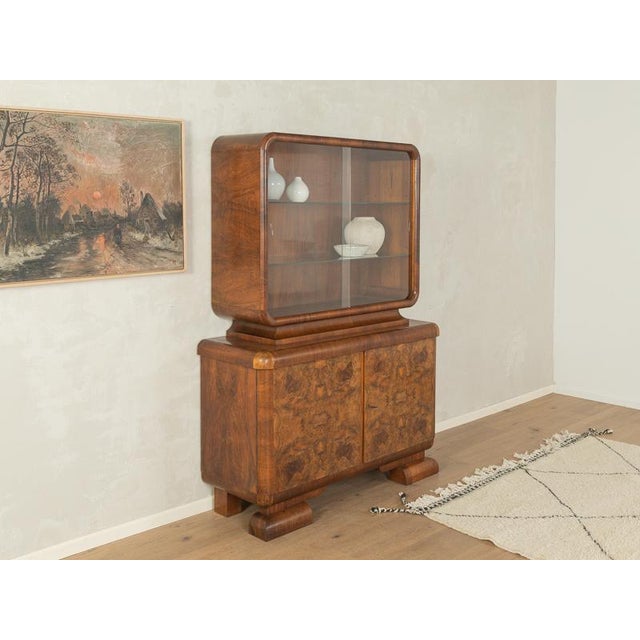 A wonderful display cabinet from the 1920s. High-quality frame in walnut burl veneer with two doors, two glass doors, one...